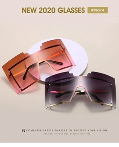 Détail de lunettes de soleil géométriques oversize avec verres dégradés et monture dorée