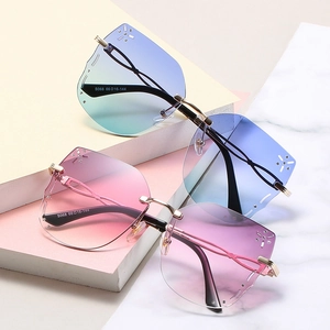 Frameless butterfly sunglasses with rhinestones and gradient lenses on marble base