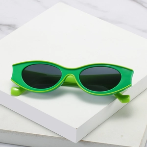 Green oval sunglasses with double-layered frames on white blocks over marble background