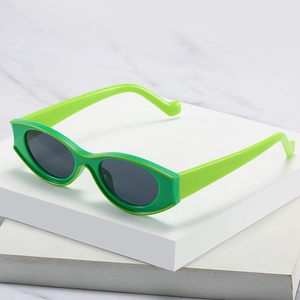 Retro green cat eye sunglasses with yellow trim and wavy temples on white pedestal