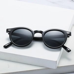 Retro round black sunglasses with silver studs on a white stone base, UV400 fashion eyewear