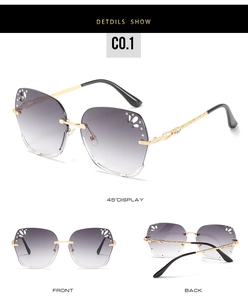 Detail view of rimless butterfly sunglasses with gradient lenses and carved gold temples