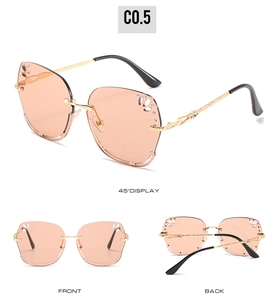 Detail view of rimless square sunglasses with floral cut-out lens and gold metal temples