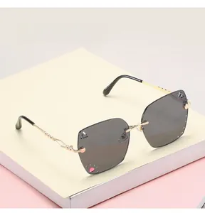Detail of rimless square sunglasses with grey gradient lenses and heart rhinestone decor