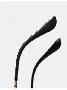Detail of matte black ergonomic temples with gold metal hinges on rimless sunglasses