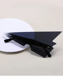 Dettaglio di occhiali da sole geometrici a trapezio con lenti nere e rivetti argento