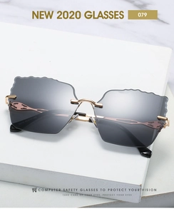 Close-up of rimless sunglasses with irregular wavy lenses and golden metal temples