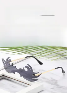 Détail de lunettes de soleil en forme de flamme avec verres gris et branches dorées