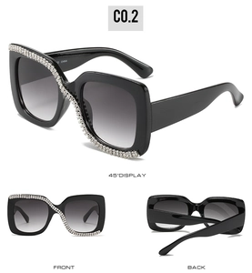 Detail of black square sunglasses featuring sparkling rhinestones and gradient lenses