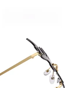 Detail of gold metal frame with black irregular lenses and silicone nose pads