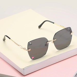Frameless oversized gray sunglasses with pink heart crystal and gold wavy metal temples