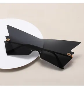Detail of oversized black cat-eye sunglasses with golden oval metal ornaments on the lens