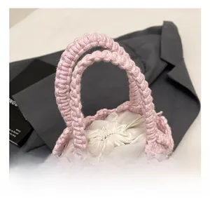 Detailed close-up of pink handmade woven cotton rope handbag with white drawstring inner bag