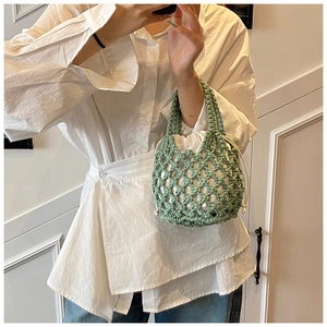 Detail of green handmade woven mesh tote bag with white drawstring inner pouch