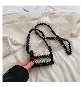 Detail of handmade woven mini pearl crossbody bag with black and white contrast beads