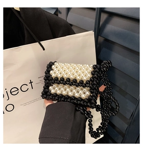 Close-up of handmade black and white beaded mini bag with elegant pearl texture