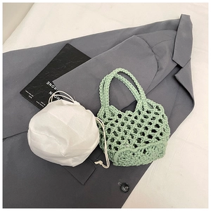Detail of light green hand-woven hollow bag with white drawstring inner liner on fabric