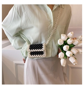 Mini pearl beaded crossbody bag featuring black and white contrast stripes on a model