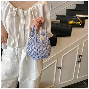 Detail of hand-woven cotton rope bucket bag with white drawstring lining in light purple
