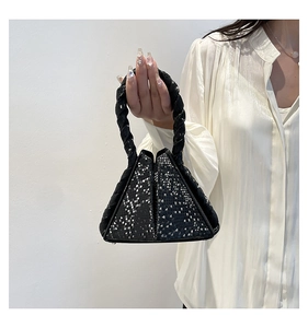 Detail of black triangular handbag with snakeskin texture and woven handle