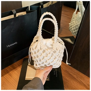 Detail view of beige woven tote bag showing cotton rope mesh and canvas drawstring liner