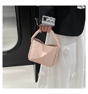 Detail of pink snake-embossed handbag with braided rope handle and geometric design