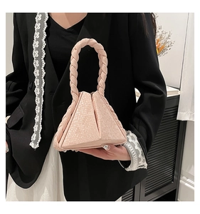 Detailed view of pink snakeskin pattern pyramid bag with thick spiral woven handle