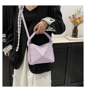 Detail of lavender geometric handbag featuring snake embossed texture and braided handle