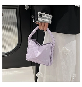 Close-up of light purple geometric handbag with snakeskin embossing and braided handle