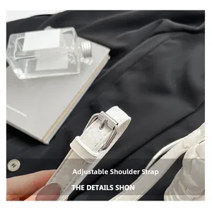 Detail of adjustable strap and silver buckle on a white embossed leather handbag