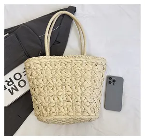 Close-up of woven beige straw tote bag showing intricate cross-knit hollow texture