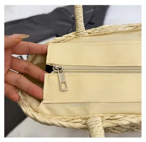 Detail of the smooth metal zipper and premium fabric lining inside the straw woven tote bag