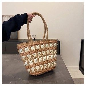 Close-up of the intricate diamond pattern weaving on the brown and beige straw tote bag