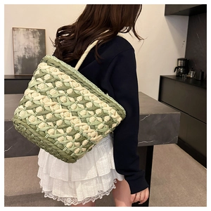 Detail of green and white checkered woven straw bag with textured rope handles