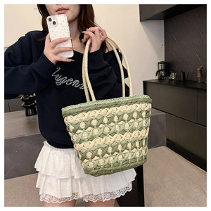 Detail of hand-woven checkerboard tote bag with braided handles for summer beach style