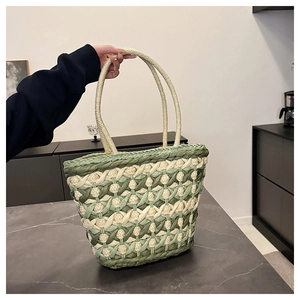 Detail of green and cream checkered woven straw tote bag with thick woven handles