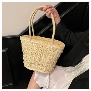 Detail of hand-woven straw tote with honeycomb texture and round handles for summer vacation