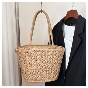 Detail of woven straw tote bag with long shoulder straps for beach and vacation use