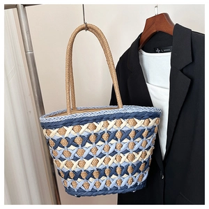 Detailed view of blue and white woven diamond patterns on a summer straw beach tote bag