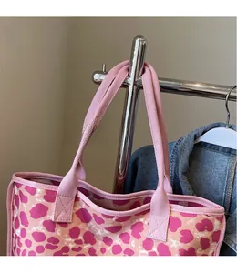 Detail of pink leopard print canvas tote bag with wide shoulder strap on hanger