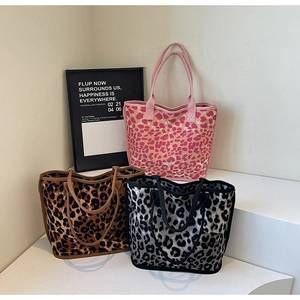 Three leopard print canvas tote bags in various colors displayed on white geometric steps