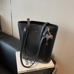 Minimalist black faux leather tote bag with gold logo and elephant charm for daily commute
