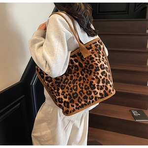 Close-up of leopard print canvas tote bag with durable brown webbing handle detail