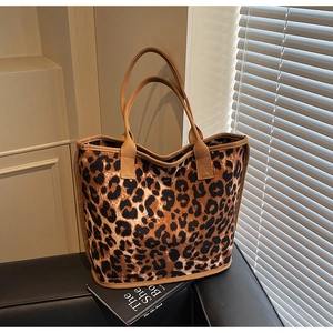 Detail of leopard print canvas tote bag with thick woven handles and soft texture
