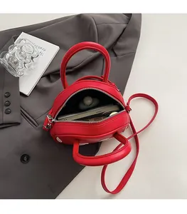 Vue de dessus du sac bandoulière rouge ouvert montrant la capacité intérieure du sac