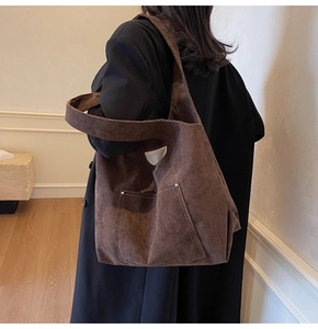 Detailed back view of a deep brown corduroy tote bag with silver rivets and wide strap