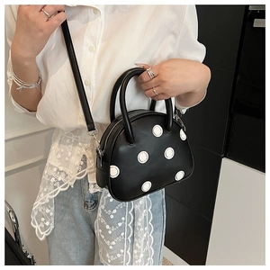 Détail du sac à main pour femme à pois noirs et blancs avec bandoulière amovible incluse