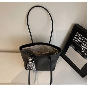 Detailed view of black tote bag interior showing the light lining and zip pocket