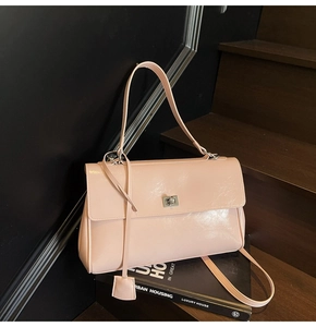 Detail of light pink patent leather tote bag with silver rotary lock and glossy finish