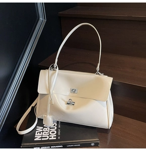 Detailed view of cream leather tote bag with silver twist lock and minimalist design